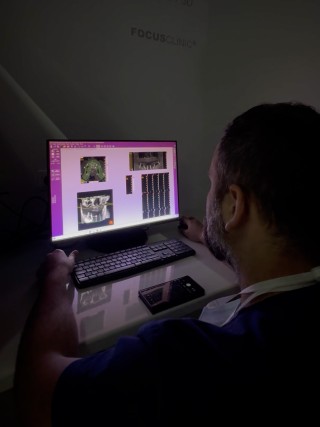 Pracownik kliniki analizuje badania diagnostyczne na monitorze