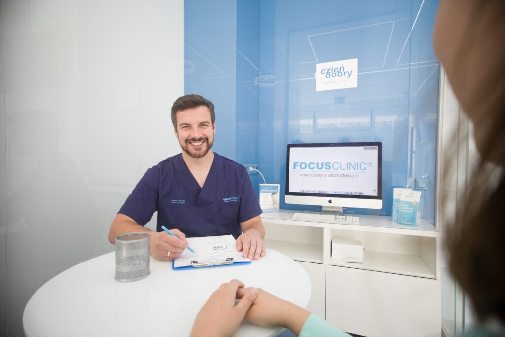 Lekarz stomatolog podczas konsultacji z pacjentem w gabinecie Focus Clinic