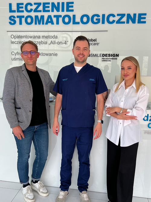 Specjaliści Focus Clinic przy tablicy informacyjnej o leczeniu stomatologicznym
